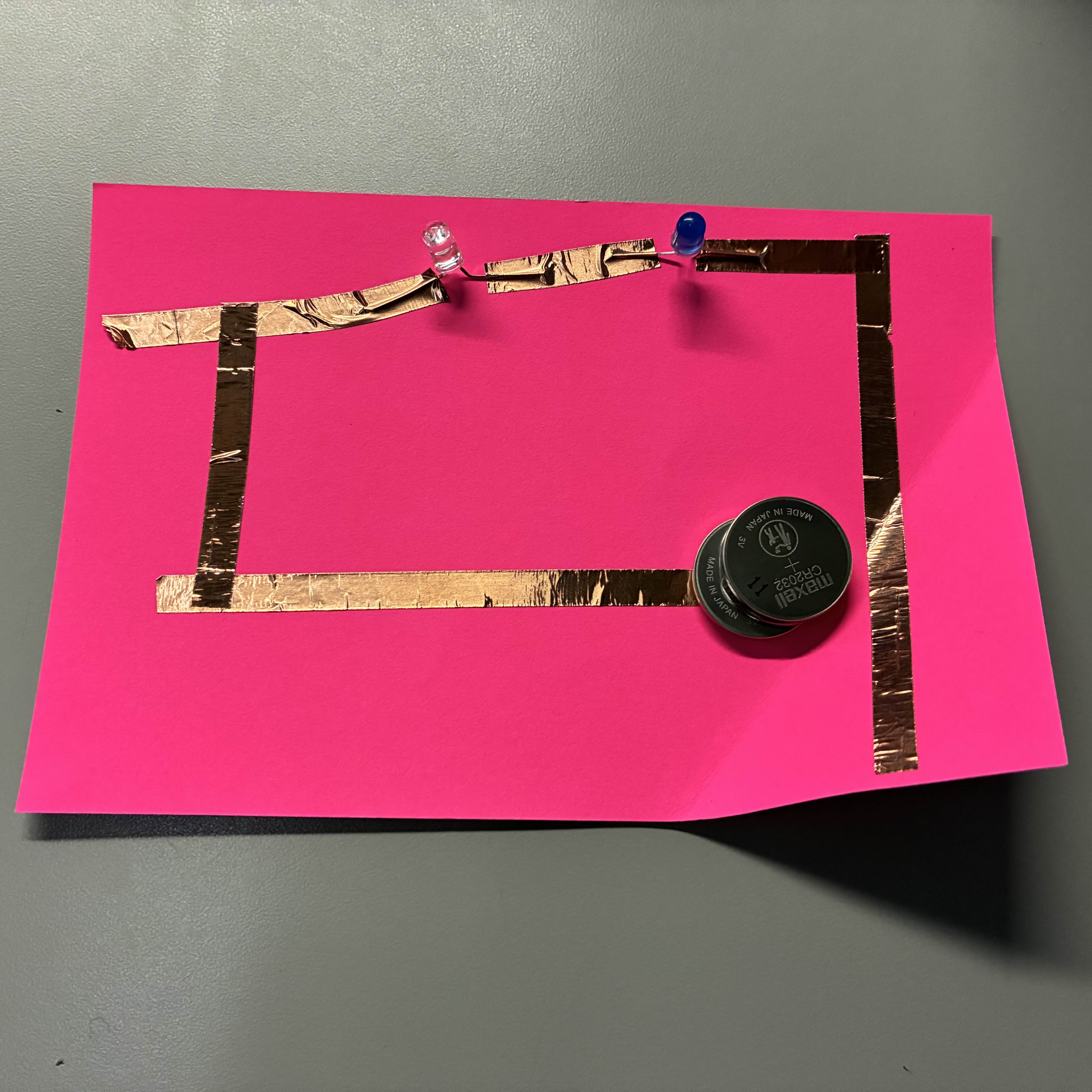 This was my final attempt at a series circuit. The way the copper tape is placed is a little bit crooked but the fold lines up and I used two batteries to power it this time.