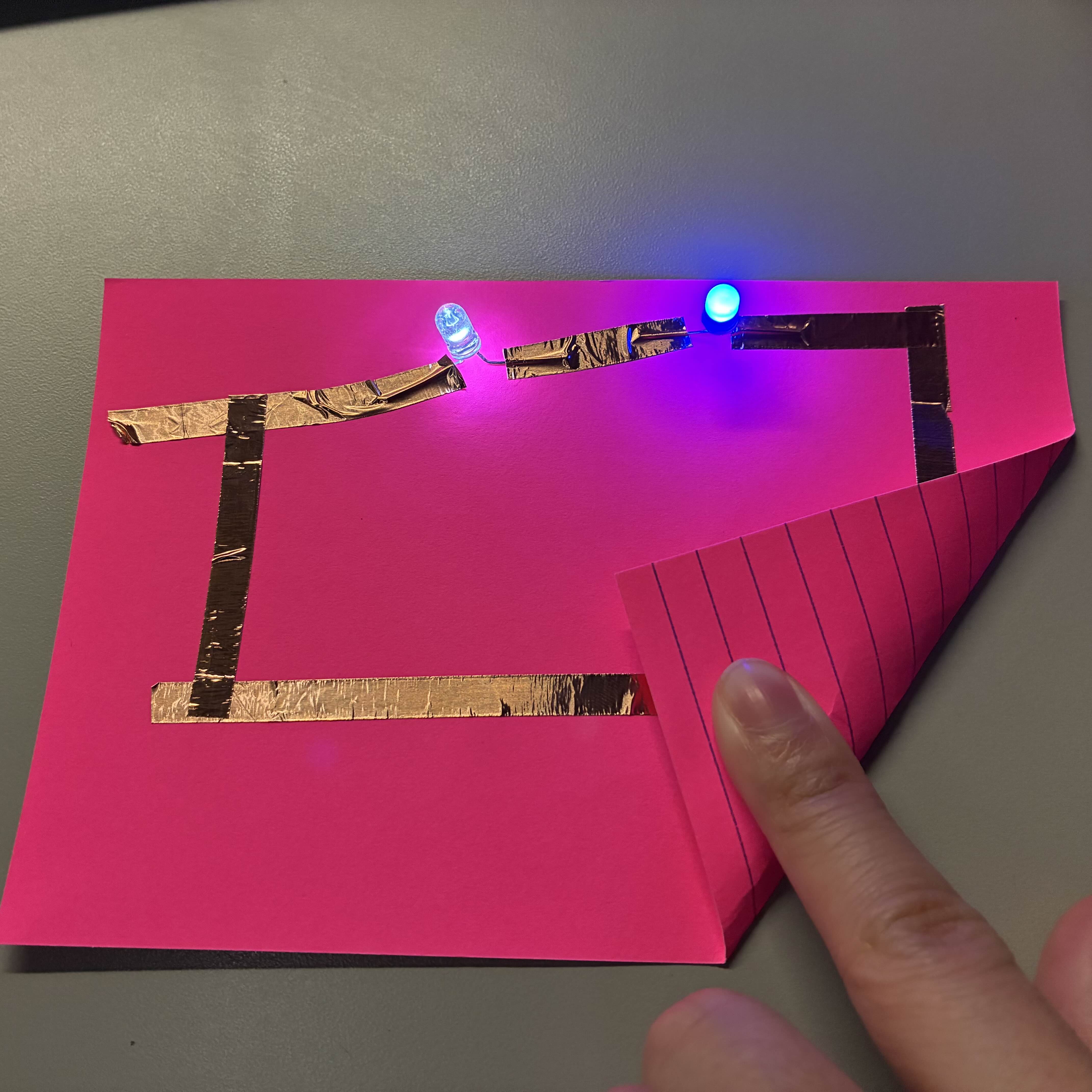 This is my functioning series circuit at a slightly lowered angle in order to see how the LED lights are taped down and to exemplify the glow coming from the lights.