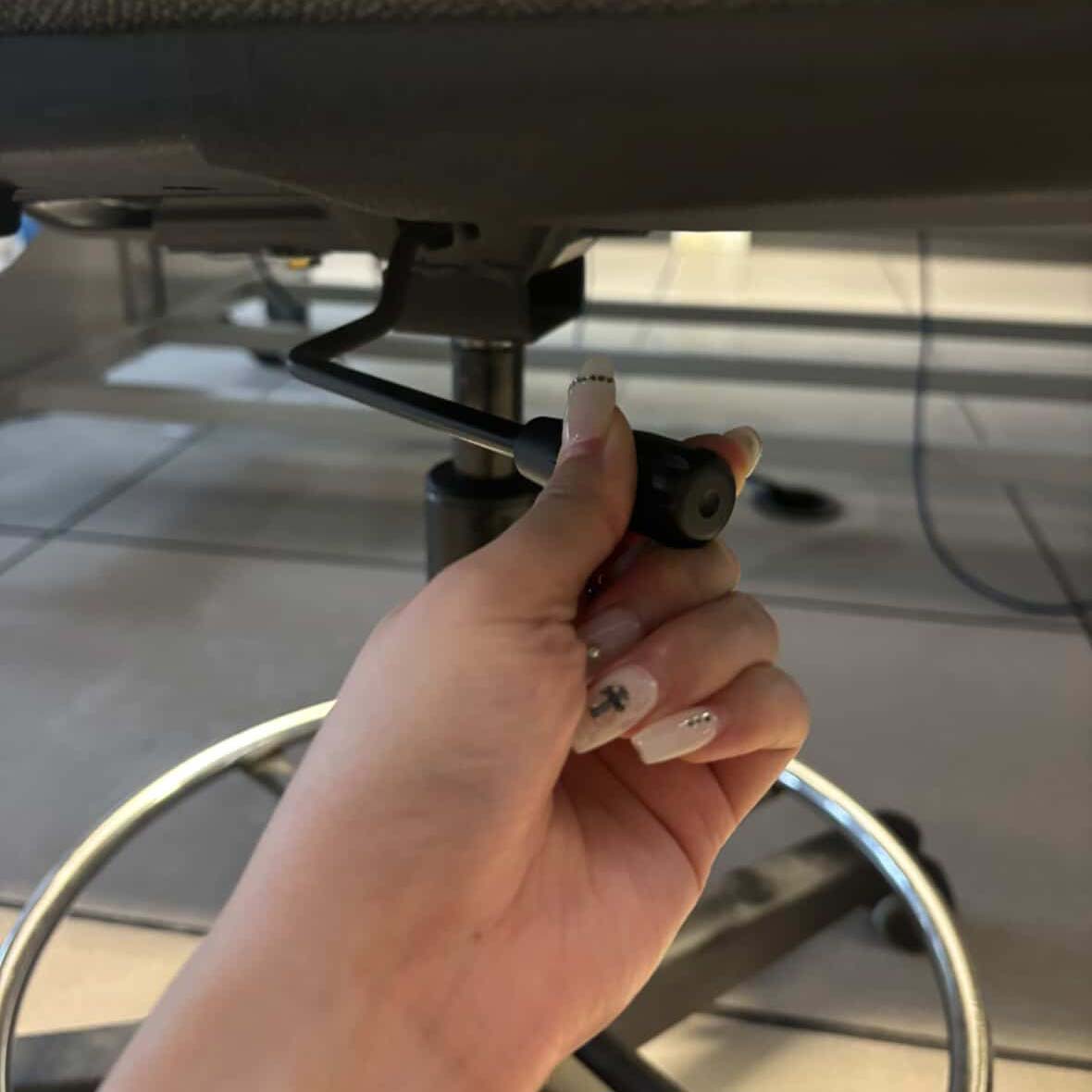 This is the lever underneath the chair's at school that can adjust the height of the chair. This is Chloe pushing the lever upwards.