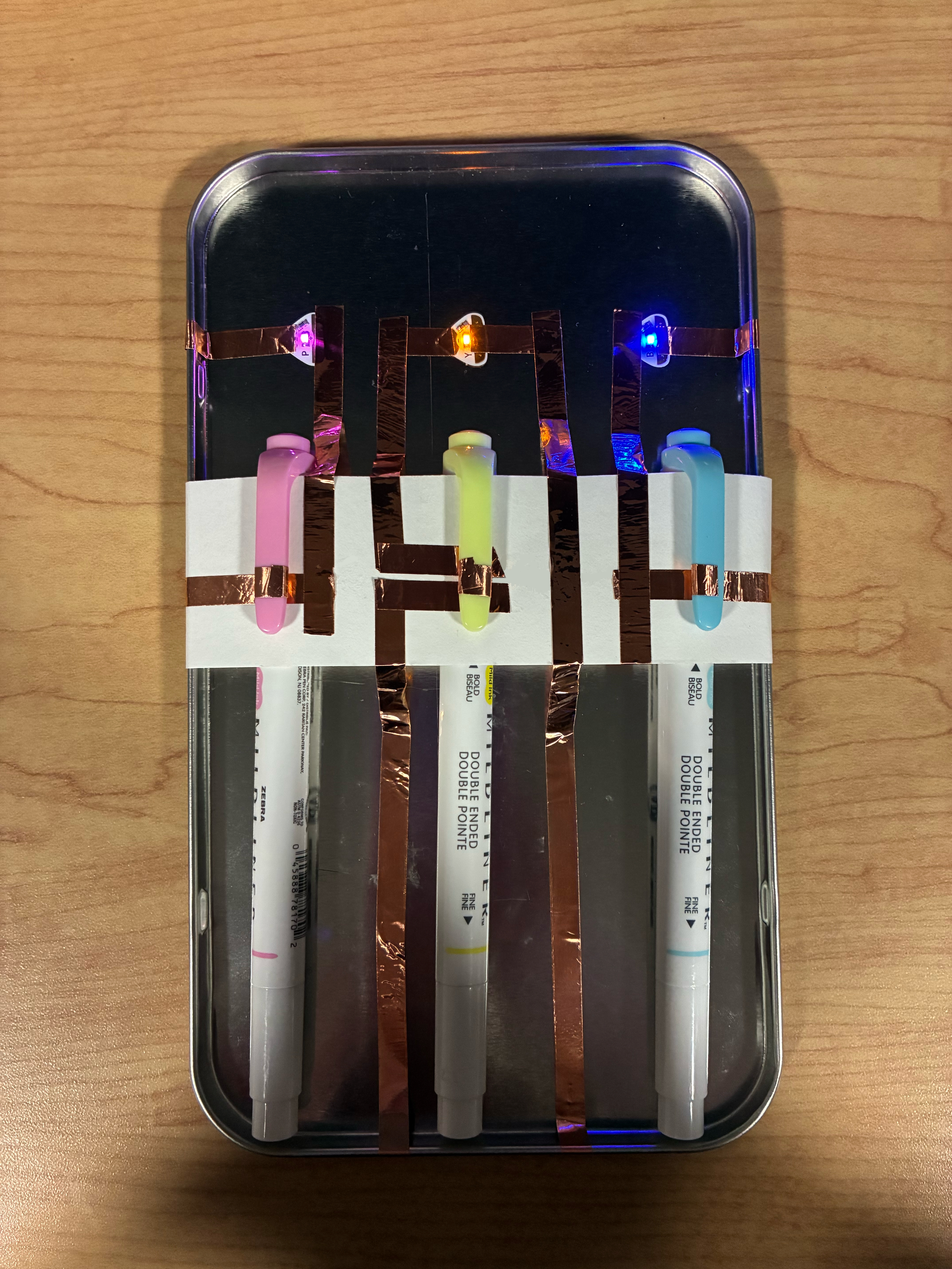 My non-wearable interactive affordance based circuit are a series of three simple circuits that have a small gap in the copper tape. The highlighters have copper tape wrapped around them and when placed inside the holder the highlighter connects the gap making the light turn on. When the highlighter is removed the connection is severed and the light will turn off.  