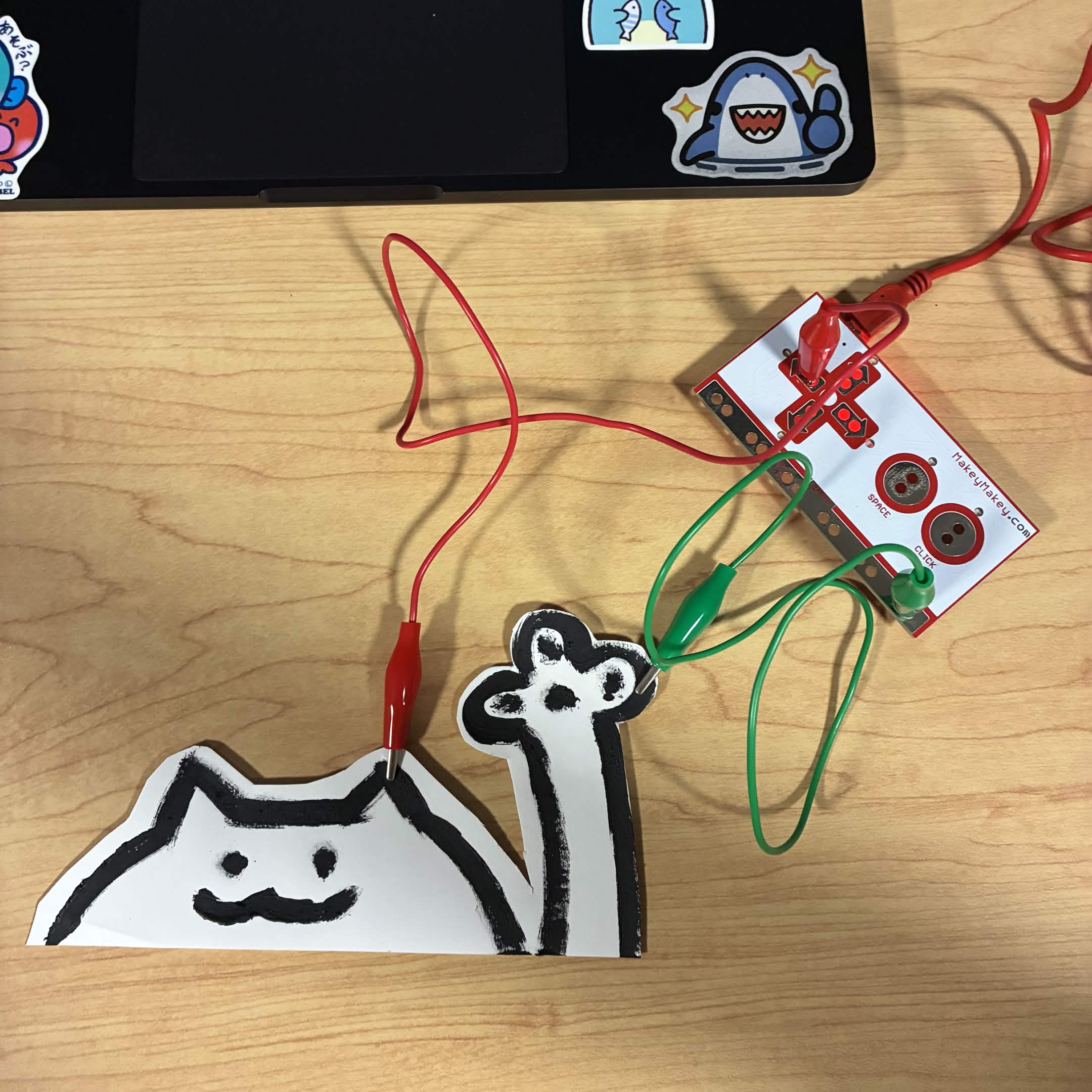 I connected the cat and paw I made out of conductive paint. The green wire is connected to the ground and the red wire is connected to the up button.